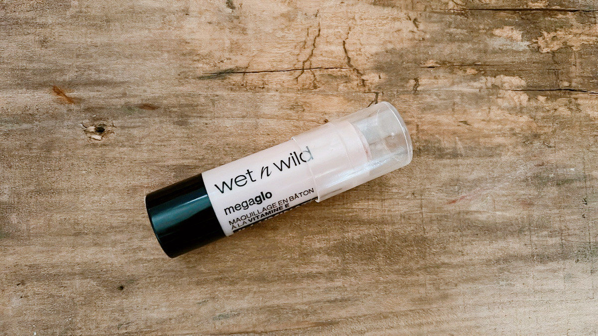 wet n wild メガグロー ビタミンEメイクアップスティック｜木目のお洒落な台に乗せた大人向けハイライト