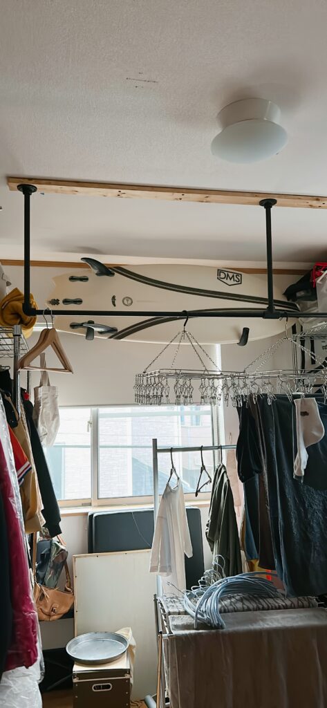 片付けが終わり、アイアンバーに洗濯物が並び、スチールラックに洋服が収まった部屋の様子。