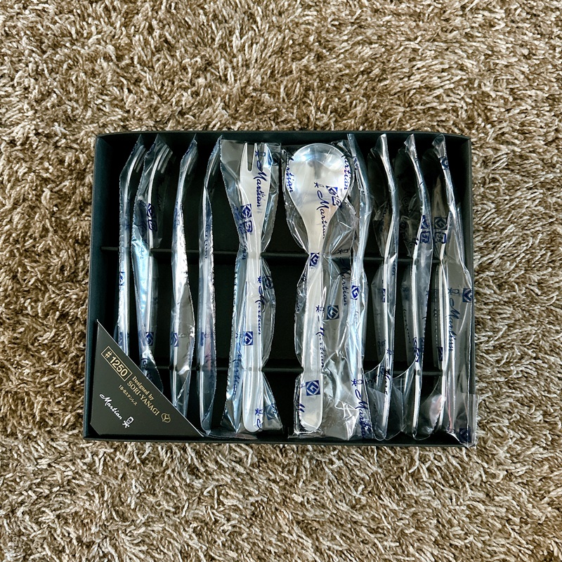 黒いギフトボックスに整然と並んだ柳宗理のカトラリーセット。ナイフ、フォーク、スプーンがそれぞれペアで、Martianのロゴ入り個包装に包まれている。