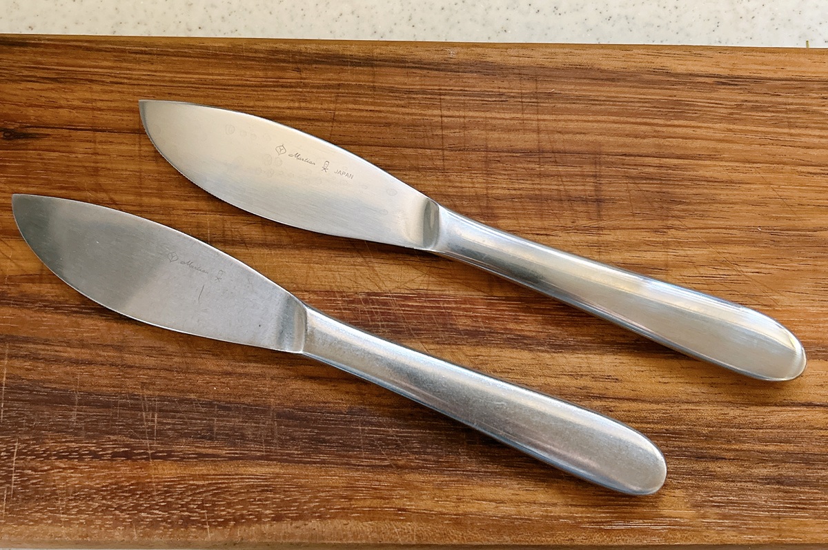 柳宗理のディナーナイフ2本を比較。上が新品（ふるさと納税返礼品）、下が20年愛用したもの。つや消しステンレスの質感の変化が見て取れる。
