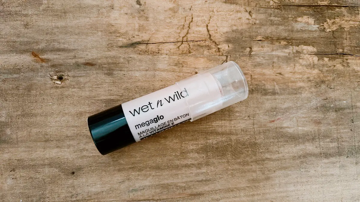 wet n wild メガグロー ビタミンEメイクアップスティック｜木目のお洒落な台に乗せた大人向けハイライト