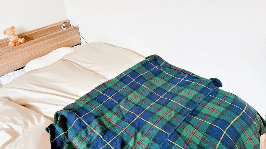 整えられた寝室のベッドとチェック柄のブランケット